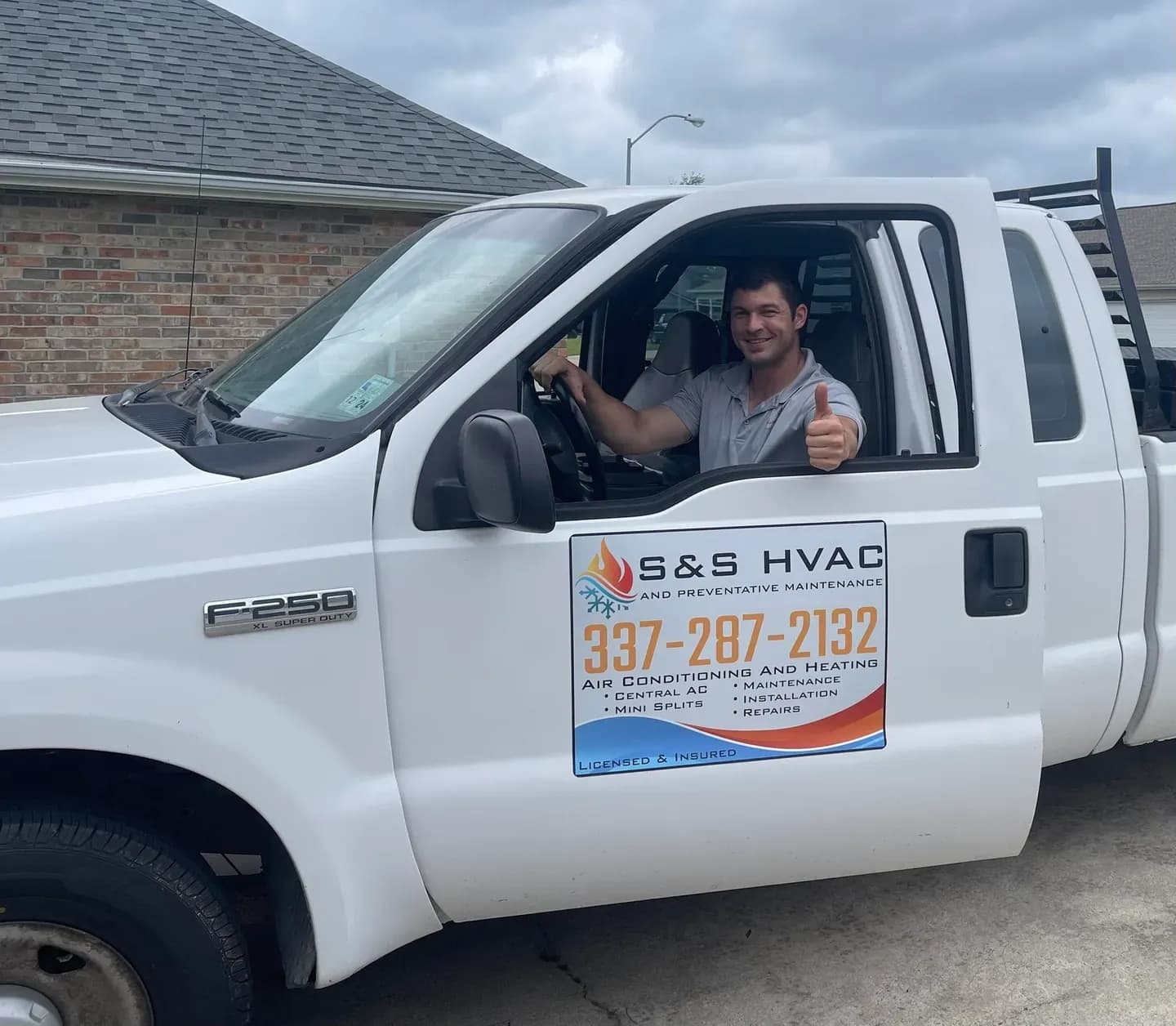 An S&S HVAC tech giving a thumbs up from the white S&S work truck, the logo and 337-287-2132 on the door